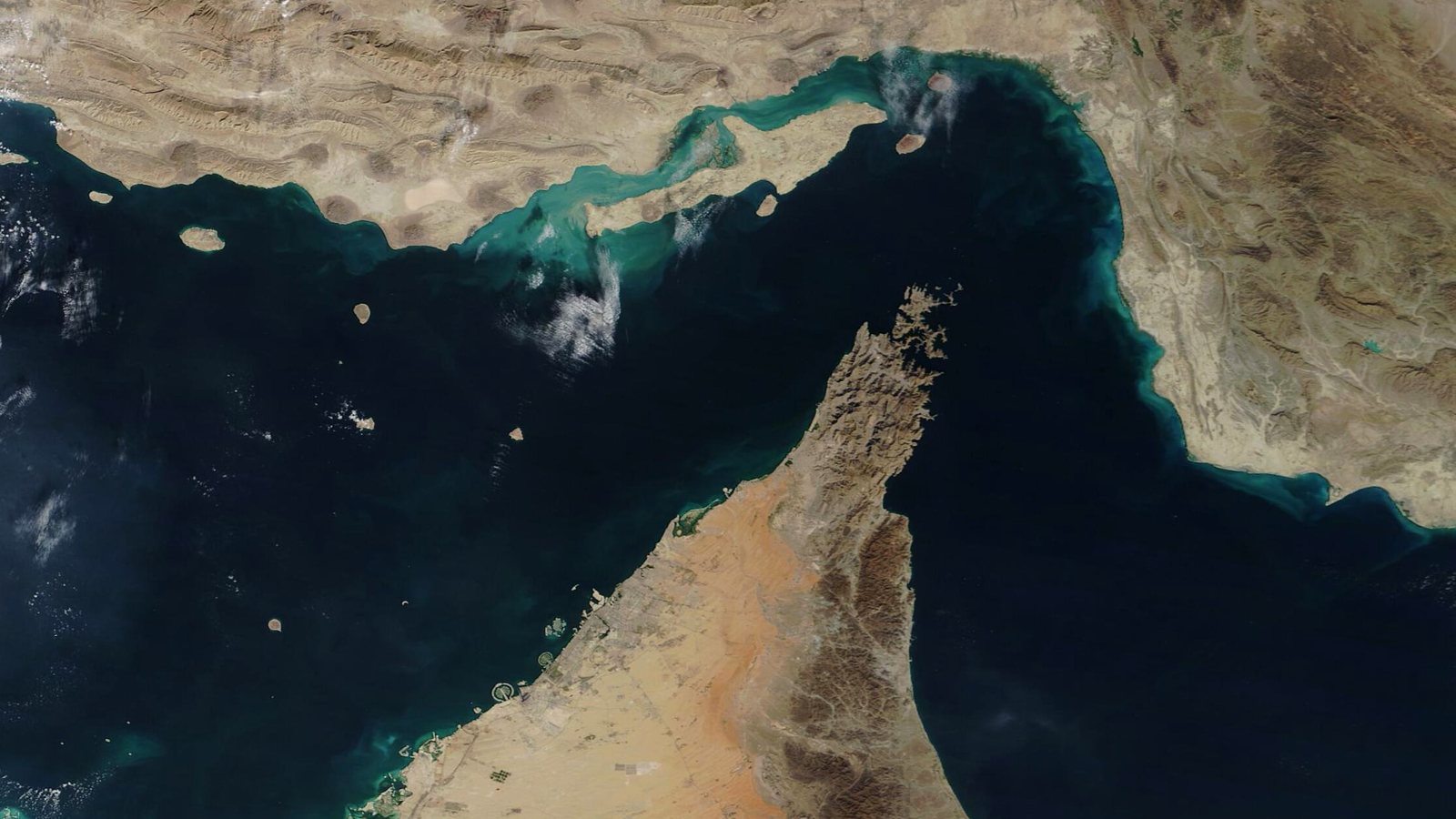 Satellite image of the Strait of Hormuz, with Iran and Qeshm Island to the north, the Musandam Peninsula of Oman pointing into the strait, the United Arab Emirates coast to the southwest and the Gulf of Oman to the east